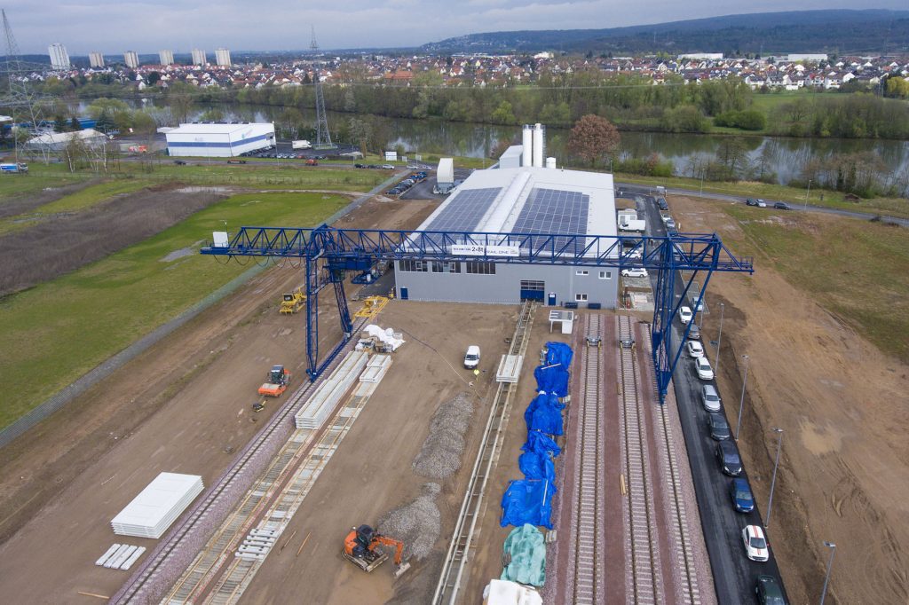 Luftbild: Werksgelände mit Portalkran und Gleisen
