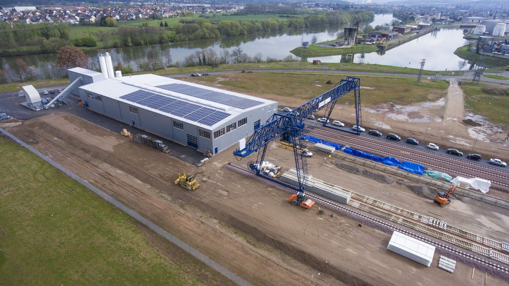 Luftbild: Produktionshalle mit Solardach am Fluss
