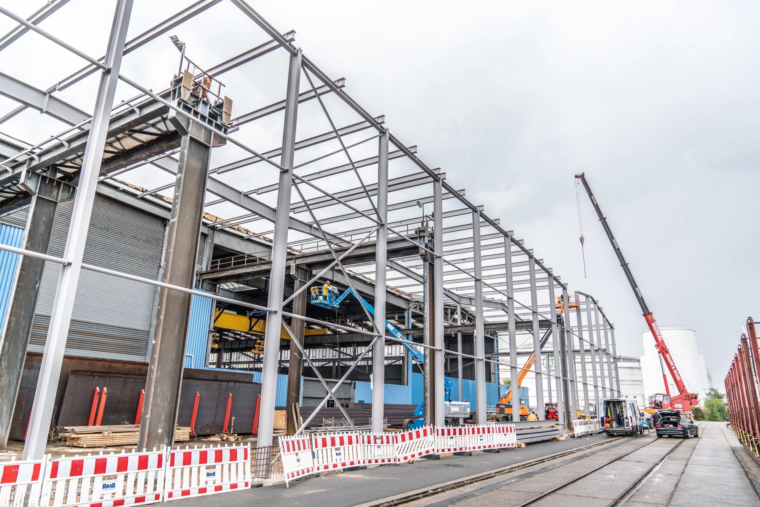 Stahlskelett einer Industriehalle im Bau mit Autokran